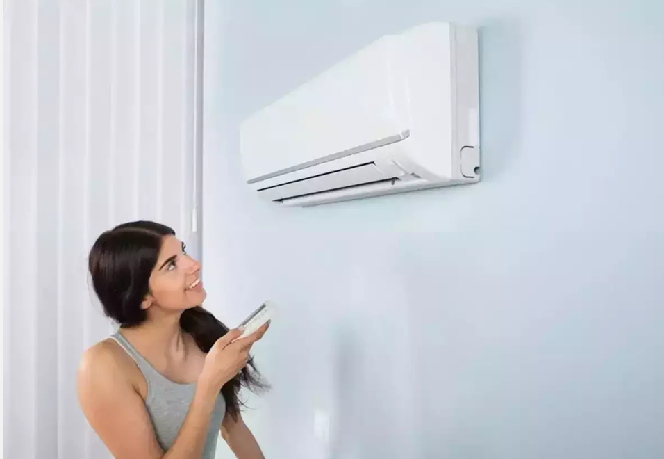 A Girl in a room turning on the AC